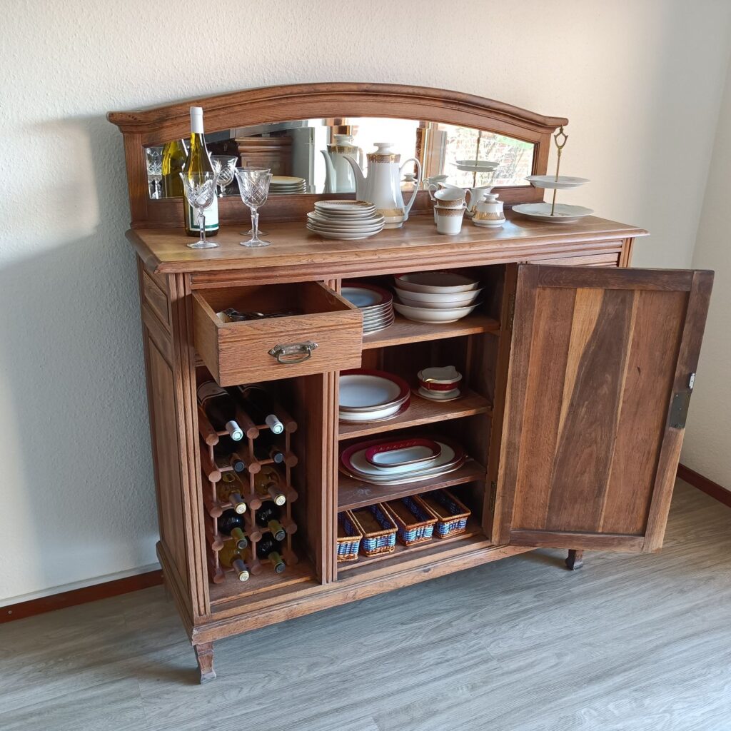 Diese antike Anrichte aus massiver Eiche hat einen dekorativen Aufsatz mit einem alten, geschliffenen Spiegel. Sie ist perfekt für dein Esszimmer. Beachte die schönen Schnitzereien vintage-style. Die schöne alte Anrichte passt auch in dein Wohnzimmer oder Küche. Die Anrichte ist in Hamburg komplett aufgearbeitet, sieht nur wenig gebraucht aus und wurde nach der Restaurierung mit Hartwachsöl versiegelt.