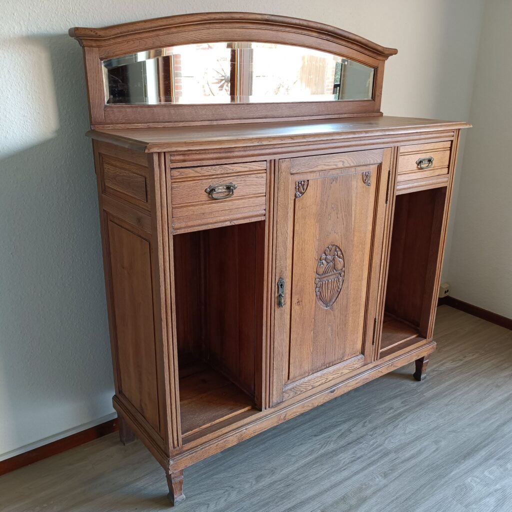 Diese antike Anrichte aus massiver Eiche hat einen dekorativen Aufsatz mit einem alten, geschliffenen Spiegel. Sie ist perfekt für dein Esszimmer. Beachte die schönen Schnitzereien vintage-style. Die schöne alte Anrichte passt auch in dein Wohnzimmer oder Küche. Die Anrichte ist in Hamburg komplett aufgearbeitet, sieht nur wenig gebraucht aus und wurde nach der Restaurierung mit Hartwachsöl versiegelt.