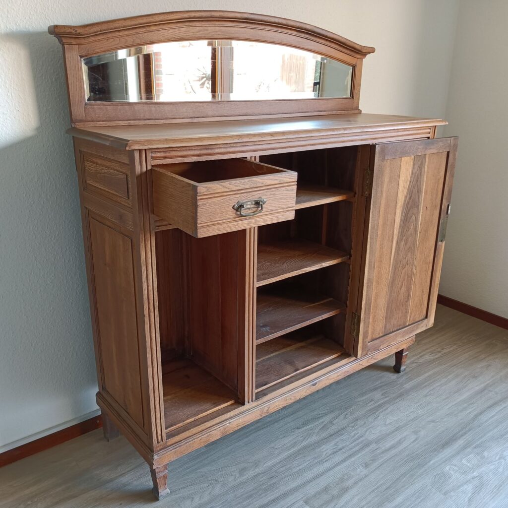 Diese antike Anrichte aus massiver Eiche hat einen dekorativen Aufsatz mit einem alten, geschliffenen Spiegel. Sie ist perfekt für dein Esszimmer. Beachte die schönen Schnitzereien vintage-style. Die schöne alte Anrichte passt auch in dein Wohnzimmer oder Küche. Die Anrichte ist in Hamburg komplett aufgearbeitet, sieht nur wenig gebraucht aus und wurde nach der Restaurierung mit Hartwachsöl versiegelt.