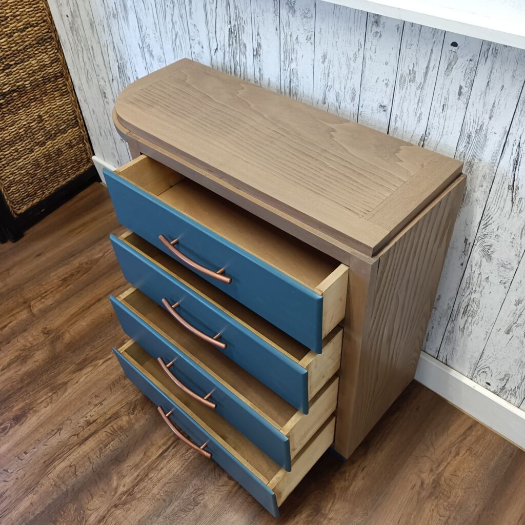 Holzkommode mit 4 Schubladen in blau und Kupfergriffen, links 3 Regale, von oben, Schubladen geöffnet