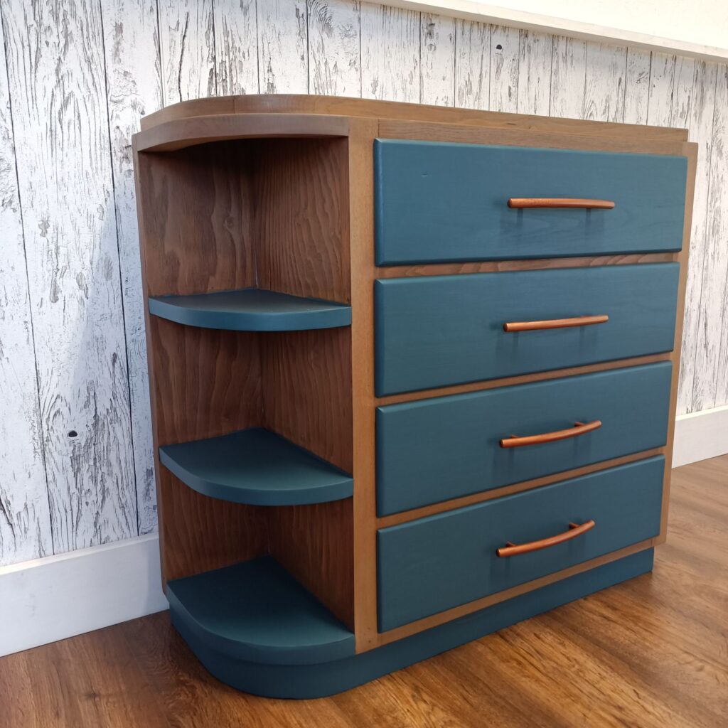 Holzkommode mit 4 Schubladen in blau und Kupfergriffen, links 3 Regale, von links