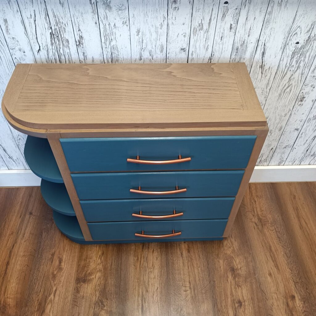 Holzkommode mit 4 Schubladen in blau und Kupfergriffen, links 3 Regale, von oben