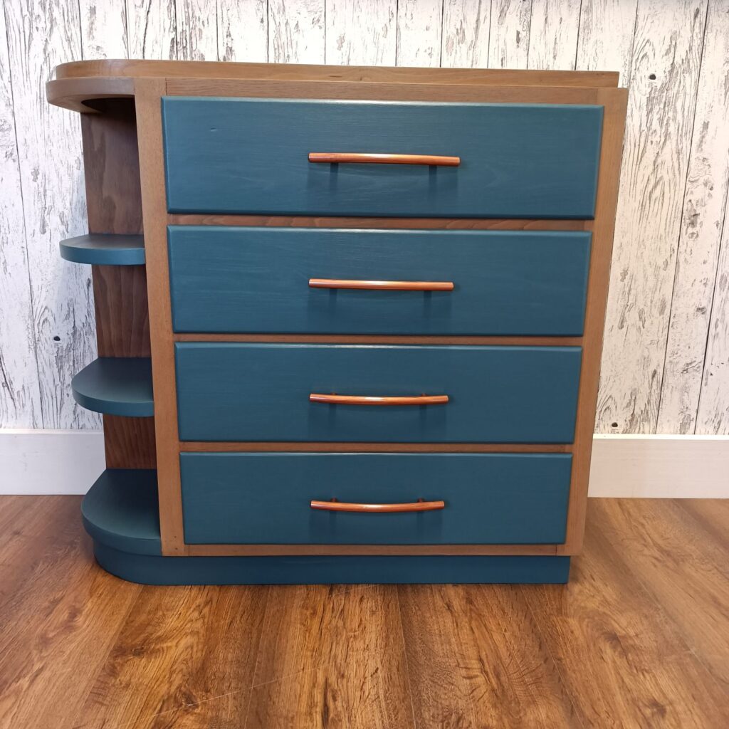 Holzkommode mit 4 Schubladen in blau und Kupfergriffen, links 3 Regale, von vorn